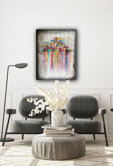 Moderner Wohnraum mit zwei grauen Stühlen, einem Tisch und einer bunten Wandkunst darüber.